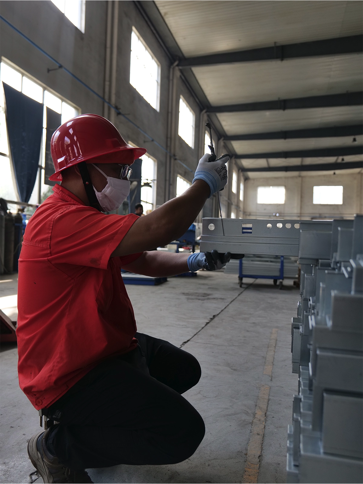 Worker inspecting processed metal components