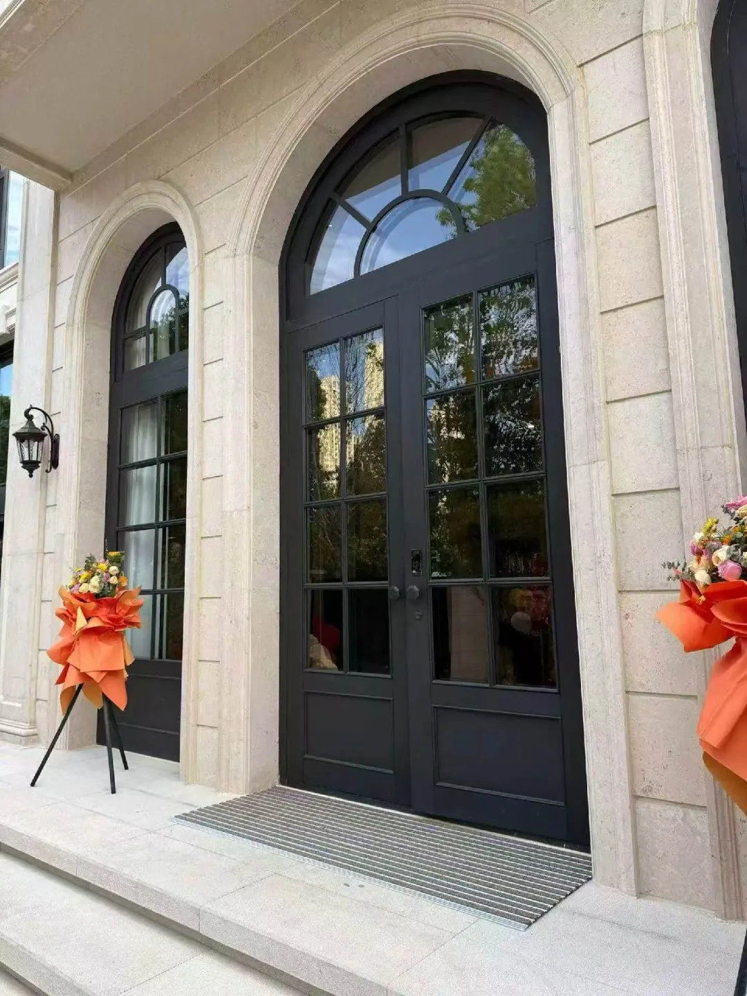 Custom black arched front doors fitted to non-standard masonry openings
