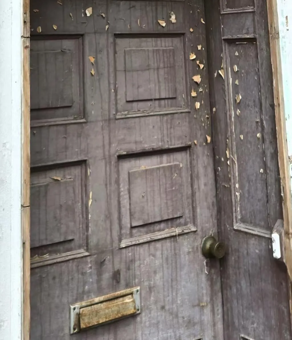 Weathered original timber front door before historic replacement